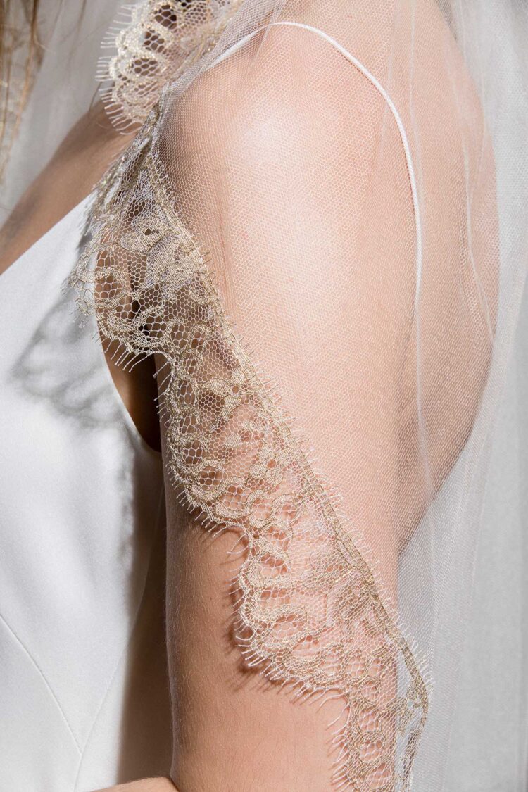 close up of gold bridal veil with delicate leavers lace trim