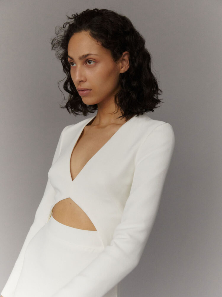 close-up on modern cut-out wedding dress with long sleeves in ivory heavy crepe